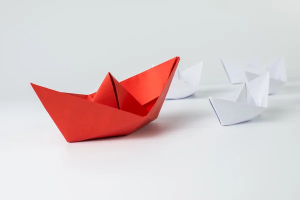 Navio de papel vermelho liderando entre branco — Fotografia de Stock