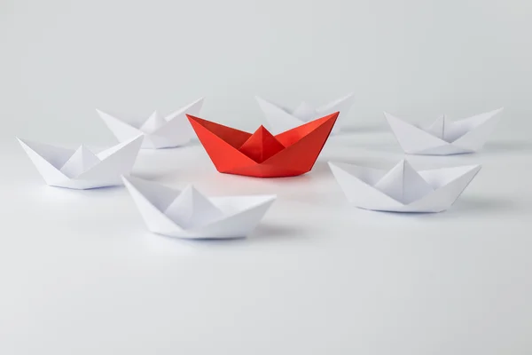 Red paper ship leading among white — Stock Photo, Image