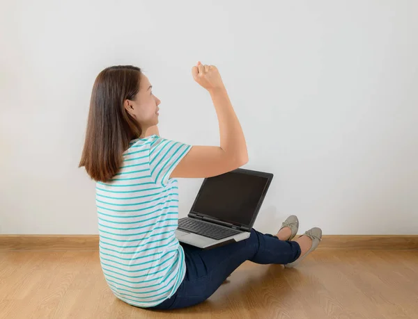 Assis sur le sol avec un ordinateur portable levant les bras avec un regard — Photo