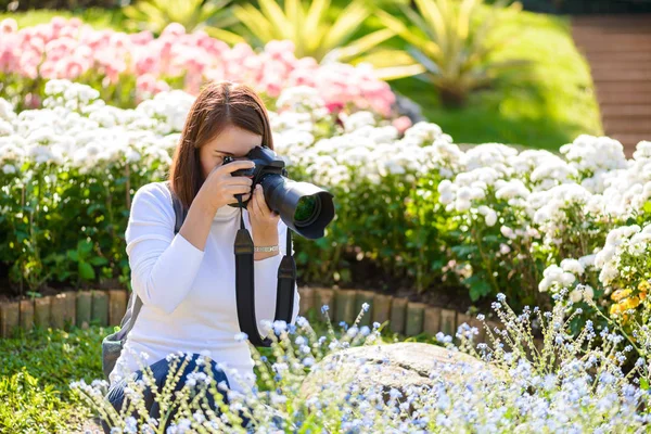 Kobieta fotograf robienia zdjęć kwiatów — Zdjęcie stockowe