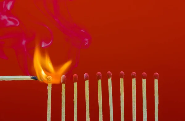 Burning matchsticks setting fire to its neighbors — Stock Photo, Image