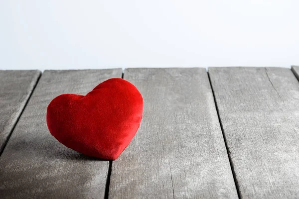 Almohadas en forma de corazón rojo sobre fondo de madera —  Fotos de Stock