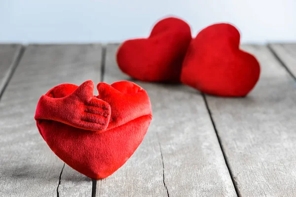 Cuscini a forma di cuore rosso su sfondo di legno — Foto Stock