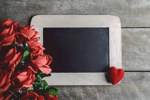 Love hearts shape, red roses and empty chalk board on wood backg — Stock Photo, Image