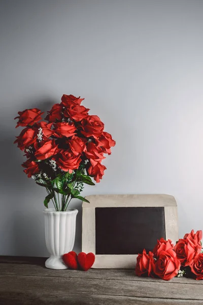 Älskar hjärtan form, röda rosor och Tom krita ombord på trä backg — Stockfoto