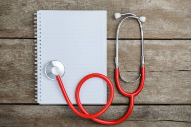 Ahşap masa üstünde defter ile sağlık stetoskop