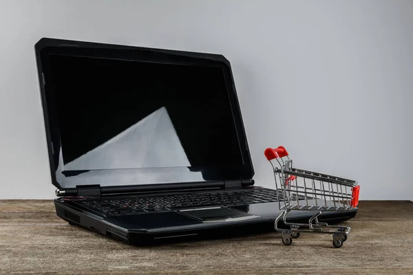 Winkelwagen en laptop — Stockfoto