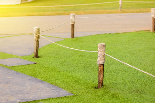 Pro blok trávy pole použít dřevěné sloupy zabalené s lanem — Stock fotografie