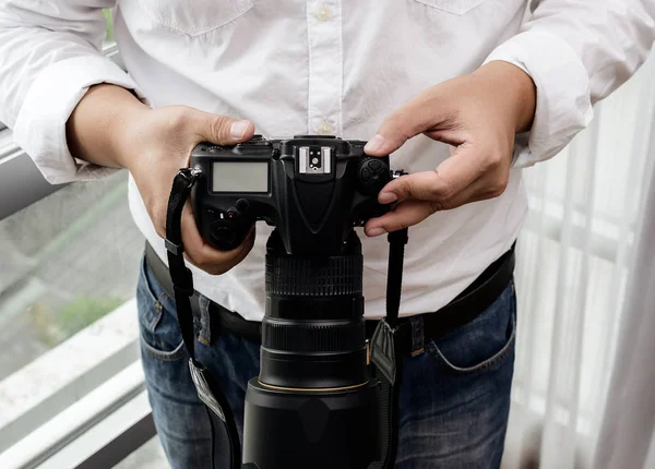 Профессиональный фотограф настраивает камеру перед съемкой — стоковое фото