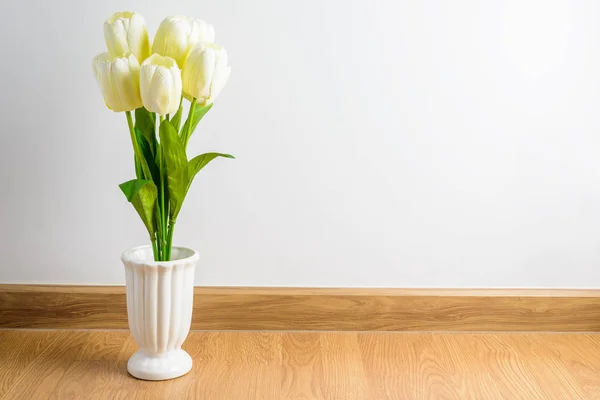 Witte tulp bloemen boeket in vaas op houten vloer voor — Stockfoto