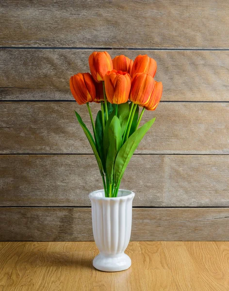 Ramo de flores de tulipán naranja en jarrón en piso de madera —  Fotos de Stock