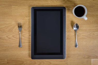 kaşık, çatal ve kahve Kupası ile ahşap masa üzerinde tablet