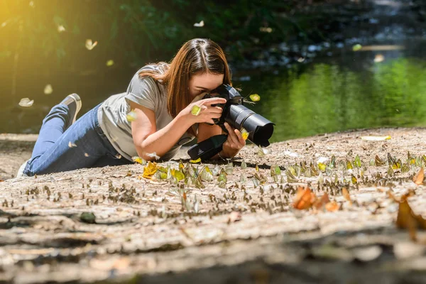 Женщины-фотографы фотографируют бабочку — стоковое фото