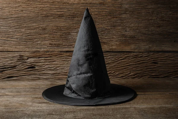 Kapelusz czarownicy na drewnianym stole — Zdjęcie stockowe