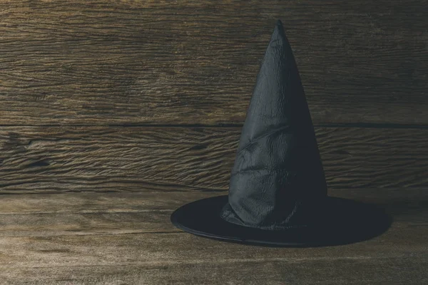 Kapelusz czarownicy na drewnianym stole — Zdjęcie stockowe