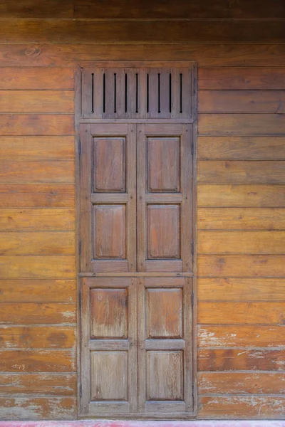 Porta de madeira estilo tailandês antigo na parede de madeira — Fotografia de Stock