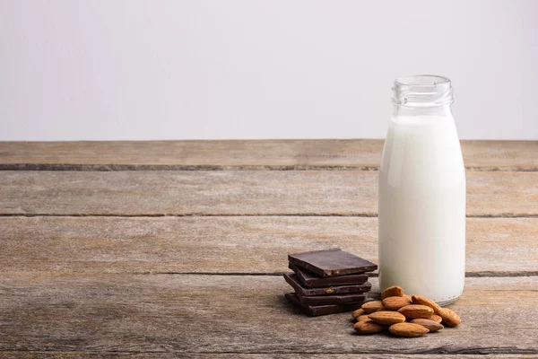 Mléko Láhvi Čokoláda Mandle Dřevěné Pozadí — Stock fotografie