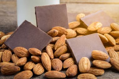 süt şişesi, çikolata ve badem ahşap arka plan üzerinde