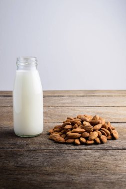 ahşap zemin üzerine badem ile şişe badem sütü