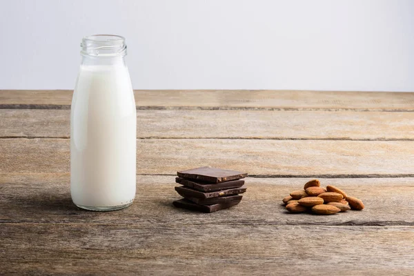 Mléko Láhvi Čokoláda Mandle Dřevěné Pozadí — Stock fotografie