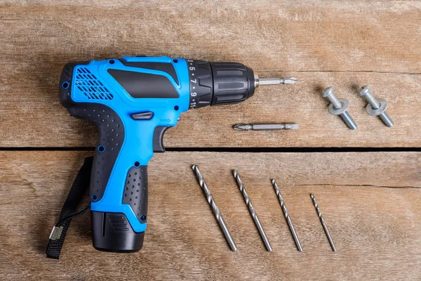 Close up Electric drill, Drill set, Screwdriver set, adapter on wooden table background and copy space. Hammer drill or screwdriver, Electric cordless hand drill on wooden.  maintenance home concept.