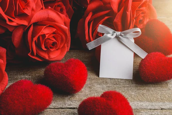 Rode rozen, rode hart en white label kaart op een houten tafel — Stockfoto