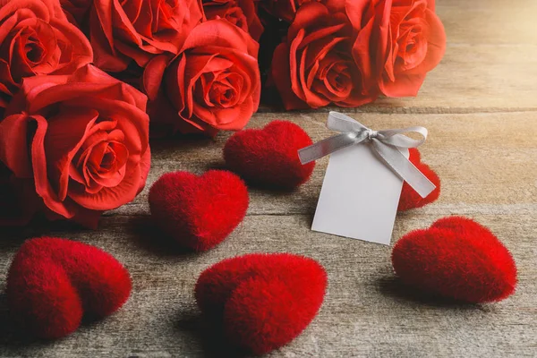 Rode rozen, rode hart en white label kaart op een houten tafel — Stockfoto