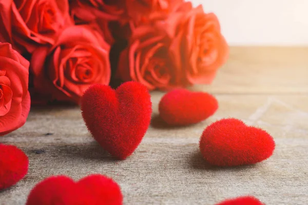 Rosas rojas, forma de corazón rojo en una mesa de madera — Foto de Stock