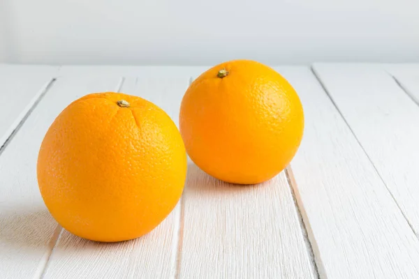 Stillleben frische Orangenfrüchte auf weißem Holztisch — Stockfoto