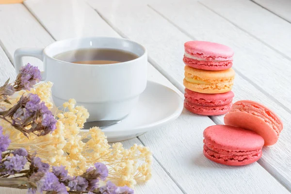 Diferentes tipos de cor de macaroons com xícara de chá quente em branco — Fotografia de Stock