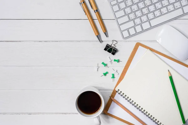 Trä vita skrivbord bord med kopp kaffe, Notebook, penna — Stockfoto