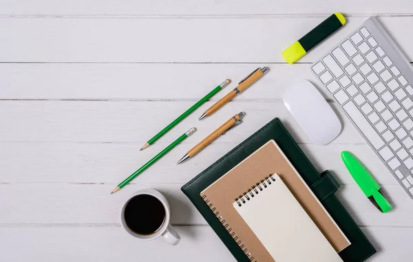 Hölzerner weißer Schreibtisch mit Tasse Kaffee, Notizbuch, Stift — Stockfoto