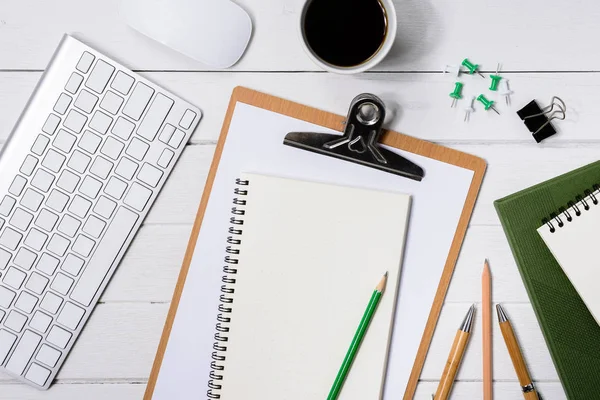 Hölzerner weißer Schreibtisch mit Tasse Kaffee, Notizbuch, Stift — Stockfoto