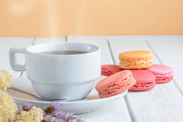 Différents types de couleurs de macarons avec tasse de thé chaud sur blanc — Photo