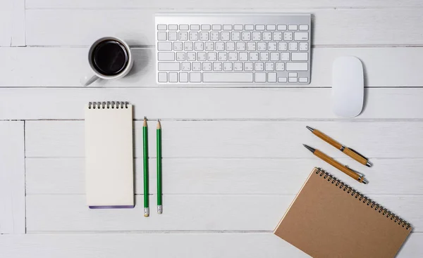 Wooden White office desk table with cup of coffee, Notebook, Pen — Stock Photo, Image