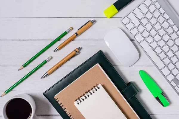 Hölzerner weißer Schreibtisch mit Tasse Kaffee, Notizbuch, Stift — Stockfoto