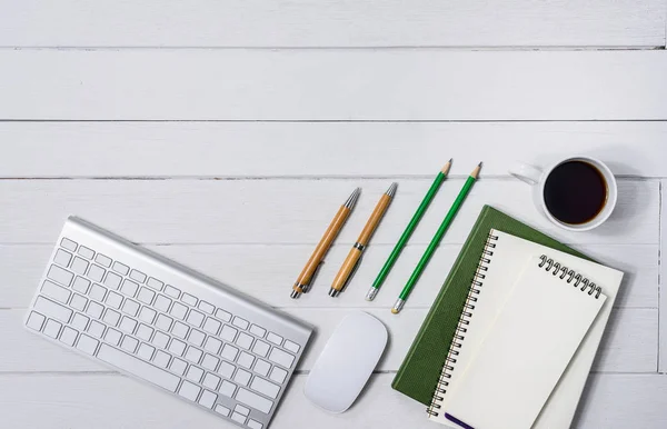 Hölzerner weißer Schreibtisch mit Tasse Kaffee, Notizbuch, Stift — Stockfoto