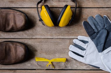 Ahşap masa üzerinde Standart inşaat güvenlik ekipmanları. Üstten Görünüm