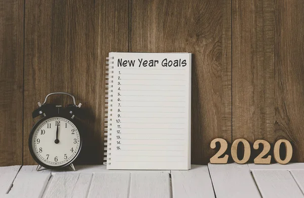 2020 drewniany tekst i lista celów noworocznych napisana na notatniku w — Zdjęcie stockowe