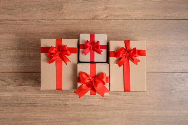 Pudełka prezentów z świątecznymi wstążkami na drewnianym tle — Zdjęcie stockowe