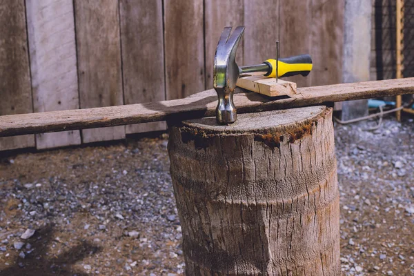 木板上的锤子和钉子概念是木匠的工具 — 图库照片