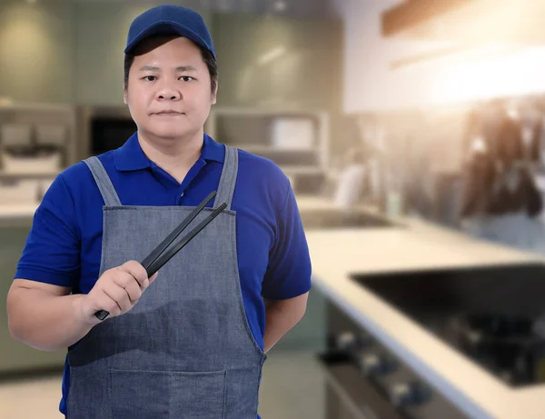 Erkek Aşçı Asistanı Mutfak Aletleri Bulanık Arka Plan Mutfağını Tutuyor — Stok fotoğraf
