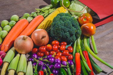 Taze yiyecek, lezzetli ve sağlıklı sebzeler ahşap masadaki kağıt alışveriş çantasından çıkar. Sağlık için sebze alma kavramı