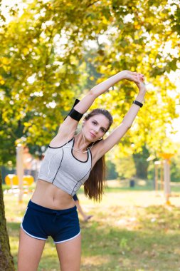 Kadın atlet kollarını sıcak sırasında kadar uzanır