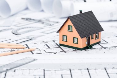 Blu üzerinde çizim araçları ve ev minyatür ile inşaat planları