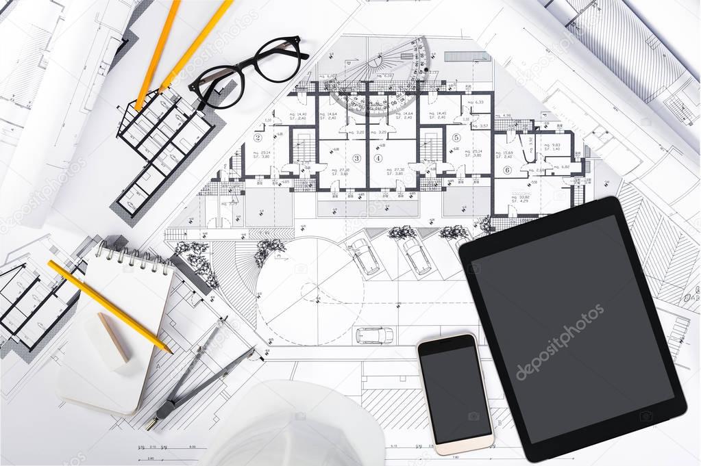 Construction plans with Tablet and drawing Tools on blueprints