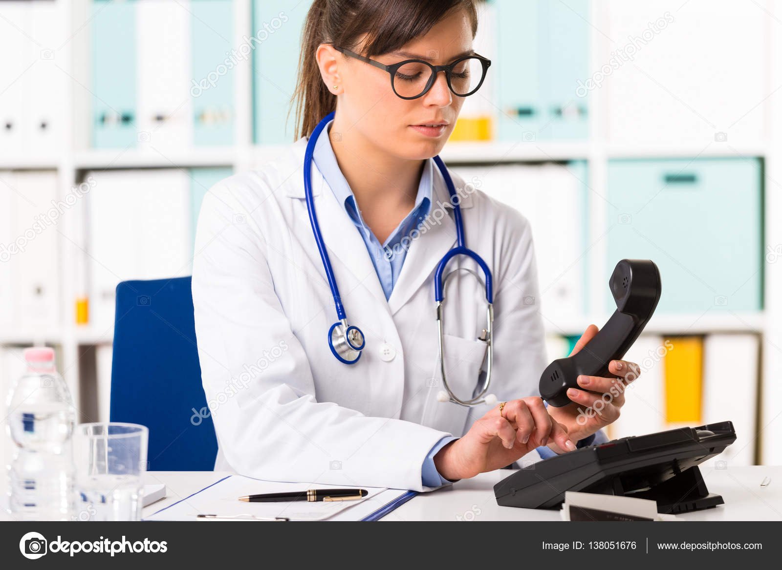 Female doctor dialling number on telephone — Stock Photo