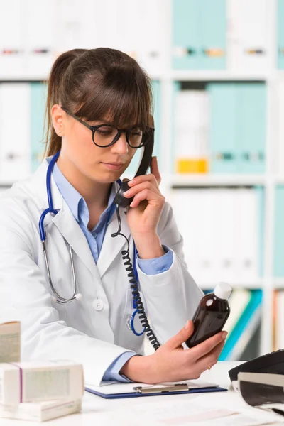 Жінка-лікар по телефону тримає ліки — стокове фото