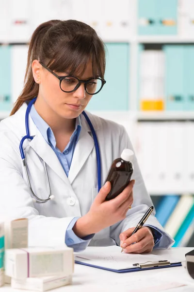 Жінка-лікар по телефону тримає ліки — стокове фото