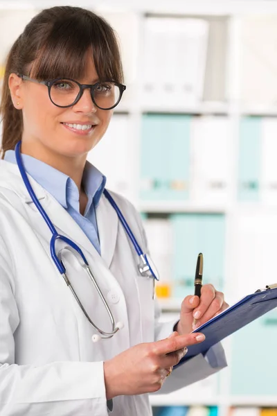 Médico sonriente con portapapeles y pluma —  Fotos de Stock